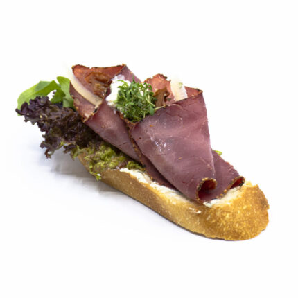 Schräggeschnittenes Baguette: Pastrami mit Krengervais auf Chili-Salsa