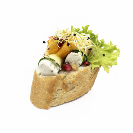 Schräggeschnittenes Baguette: Ziegenkäse-Zucchiniröllchen mit Safran-Birnen-Relish & Granatapfel